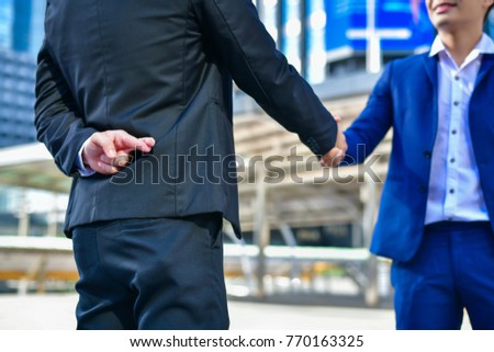 Business concept hypocrisy, Young businessmen shake hands with fraudulent models.
