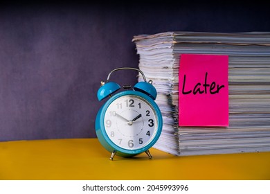 Business concept. Layout of alarm clock, stack of papers and note with text Later reference to procrastinate - Shutterstock ID 2045993996