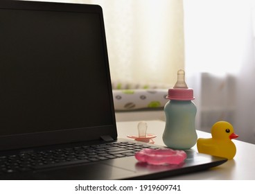 Business concept for the leave of absence for an expectant or new mother Trendy.  Pacifier on the laptop and baby bottle. 
Working in a decree. Maternity leave concept.  - Shutterstock ID 1919609741