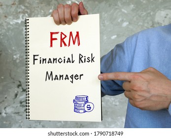 Business concept meaning Financial Risk Manager FRM with sign on the piece of paper.