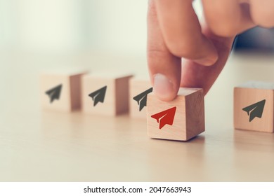 Business Concept For New Ideas Creativity And Innovative Solution. Business Opportunity Concept.  Businessman Chooses Red Paper Plane Symbol On Wooden Cube Standing With Others On White Background.