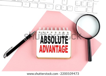 Business concept. Notebook with text ABSOLUTE ADVANTAGE on pink paper with magnifier, keyboard and pen in white background