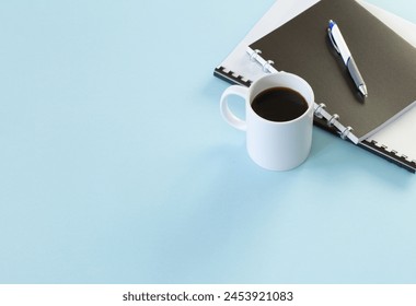 business concept with notebooks, pen and cup of coffee  on blue background