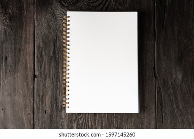business concept, notepad for notes with a white sheet on a wooden dark brown table in rustic style