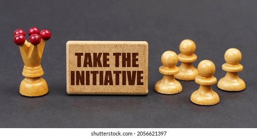 Business concept. On a black background, chess and a sign with the inscription - TAKE THE INITIATIVE