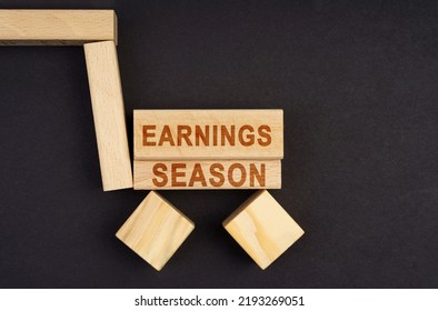 Business Concept. On A Black Surface, A Cart Made Of Blocks And Cubes With The Inscription - Earnings Season