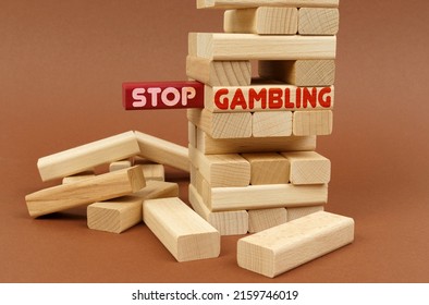 Business concept. On a brown surface stands a wooden block tower. On the red block there is an inscription - Stop, on the next block - Gambling