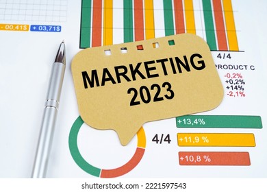 Business concept. On the business charts is a pen and a sign with the inscription - Marketing 2023 - Shutterstock ID 2221597543