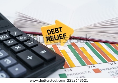 Business concept. On the business charts there is a notepad, a pen and an arrow sticker with the inscription - Debt Relief