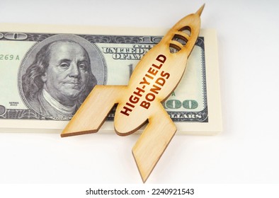Business concept. On the dollars lies a wooden model of a rocket with the inscription - High-Yield Bonds - Shutterstock ID 2240921543