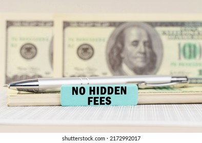 Business concept. On the dollars are a pen and a sign with the inscription - No hidden fees. In the background in a blurred background are dollars
