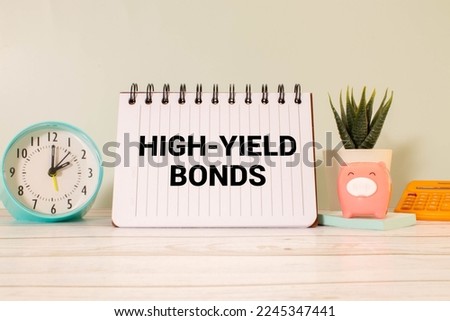 Business concept. On the financial charts lies a pen and a sign with the inscription - high yield bonds.
