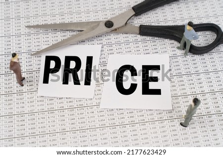 Business concept. On financial reports, scissors, figurines of people and cut paper with the inscription - price