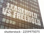 Business concept. On the glass surface of the business center there is an inscription - Leasehold vs Freehold