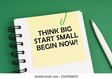 Business Concept. On A Green Surface, A Pen, A Notepad With Stickers And The Inscription - Think Big Start Small Begin Now