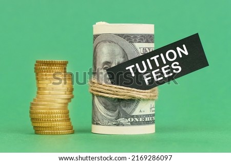 Business concept. On a green surface are coins and dollars in a bundle. On the dollar sign with the inscription - Tuition Fees