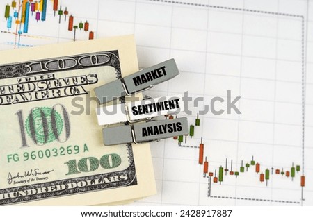 Business concept. On the quote chart there are dollars and clothespins with the inscription - Market Sentiment Analysis