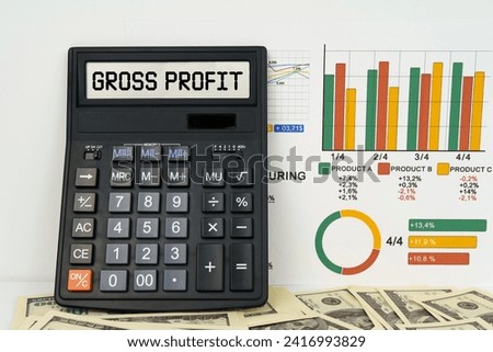 Business concept. On the table are financial reports, dollars and a calculator with the inscription - gross profit