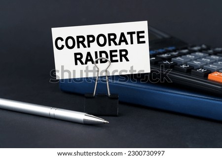 Business concept. On the table is a notebook, a calculator, a pen and a business card with the inscription - Corporate Raider