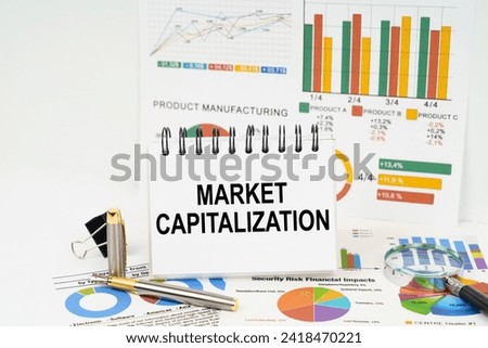 Business concept. On the table are reports with graphs and a notepad with the inscription - Market capitalization