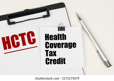 Business concept. On the tablet is a sheet of paper with the inscription - HCTC and stickers with the inscription - Health Coverage Tax Credit, next to the pen.