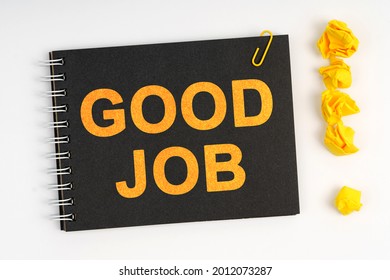 Business concept. On a white background lies a marker, an exclamation mark made of paper and a notebook with the inscription - GOOD JOB