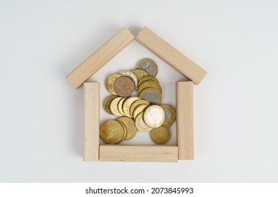 Business concept. On a white background, a small house made of wooden boards, inside a coin.