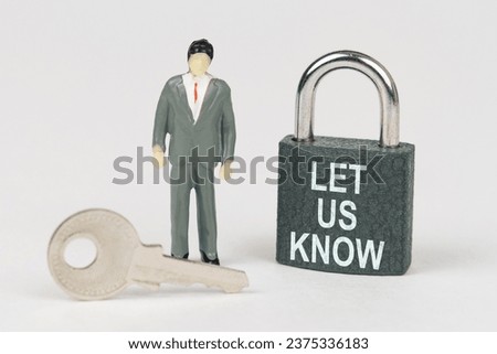 Business concept. On a white surface there is a figurine of a businessman, a key and a lock with the inscription - Let Us Know