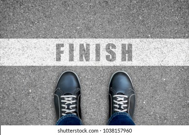 Business concept. One in black shoes standing at the finish line. - Shutterstock ID 1038157960
