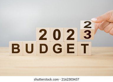 Business concept of planning 2023. Businessman flips wooden cube and changes words BUDGET 2022 to BUDGET 2023. New year business plan concept in 2023. Economy and business.Phrase 2023 BUDGET - Shutterstock ID 2162303437