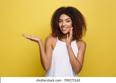 Business Concept - Portrait Of Beautiful Calm Young African American Presenting By Pointing Hand On Side. 