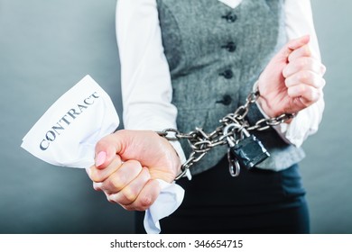 Business concept. Serious woman businesswoman with chained hands holding contract, side view grungy background