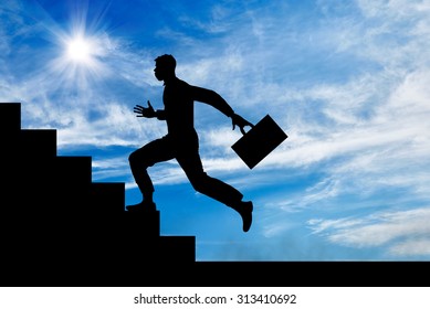 Business Concept. Silhouette Of A Man With A Briefcase Running Up The Stairs.