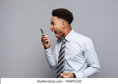 Business Concept - Stressful african american businessman shouting and screaming on mobile phone.