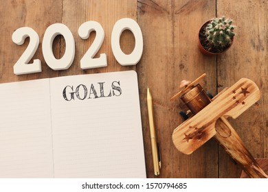 Business Concept Of Top View 2020 Goals List With Notebook Over Wooden Desk