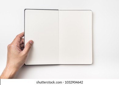 Business concept - Top view of man's hand hold black hardcover notebook isolated on background for mockup