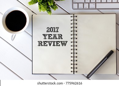 Business concept - Top view notebook with keyboard and coffee cup  writing 2017 Year Review
