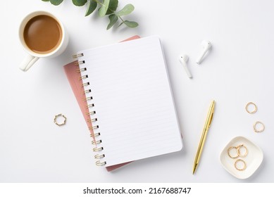 Business concept. Top view photo of workplace open planner pen eucalyptus cup of coffee gold rings and wireless earbuds on isolated white background with blank space - Powered by Shutterstock