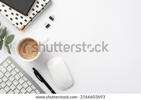 Business concept. Top view photo of workstation keyboard computer mouse black and white stationery note pads pen binder clips cup of coffee and eucalyptus on isolated white background with copyspace