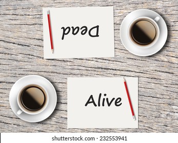 Business Concept : Two Coffee, Papers And Pencils On The Table  Facing Each Other Head To Head To Compare Between Alive And Dead.