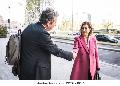 Business concept: two partners shaking hands standing in front of company office, couple of business person satisfied by the agreement, successful entrepreneurs deal - Powered by Shutterstock