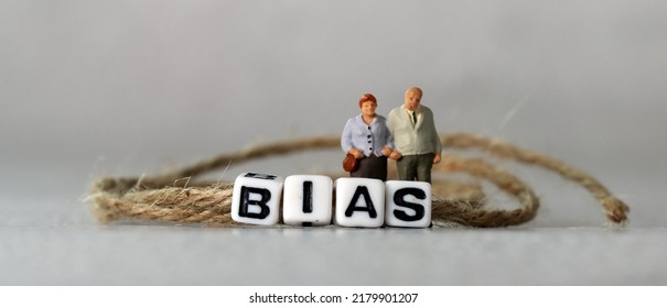 Business concept with white cube arranged in the word  ’BIAS' and miniature people. The concept of prejudice against the elderly and the infirm. - Shutterstock ID 2179901207