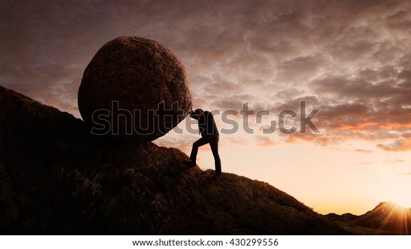 Business concept, Young businessman pushing large\
stone uphill with copy\
space