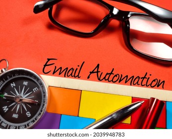 Business concept.Text Email Automation with compass,glasses,pen and wooden puzzle on red background.