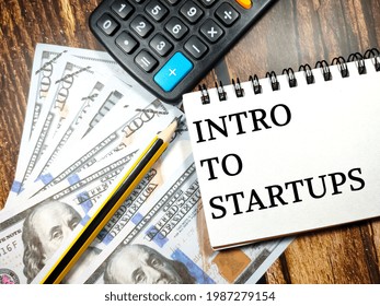 Business Concept.Text Intro To Startups With Banknote,pencil And Calculator On Wooden Table Background.