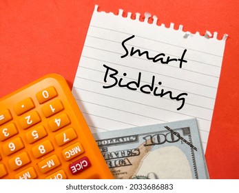 Business Concept.Text Smart Bidding Writing On Notepaper With Fake Money And Calculator On Red Background.