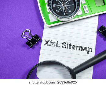 Business Concept.Text XML Sitemap Writing On Notepaper With Magnifying Glass,compass,calculator And Paper Clips On Purple Background.