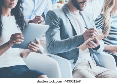 Business conference. Close-up of young people sitting on conference together and making notes - Powered by Shutterstock