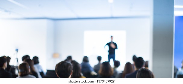 Business Conference Photo. Executive Speaker On Stage. Business Presentation Presenter Speech At Tech Entrepreneur Meeting. Corporate Event Audience. Expert Seminar Lecture Conference Event. Blurred.