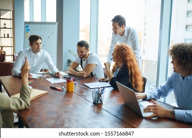 A business consultant explaining his ideas and methods to a group of corporate employees. A meeting at the conference hall. Workers learning new techniques. Atmosphere of growth and success. - Shutterstock ID 1557166847
